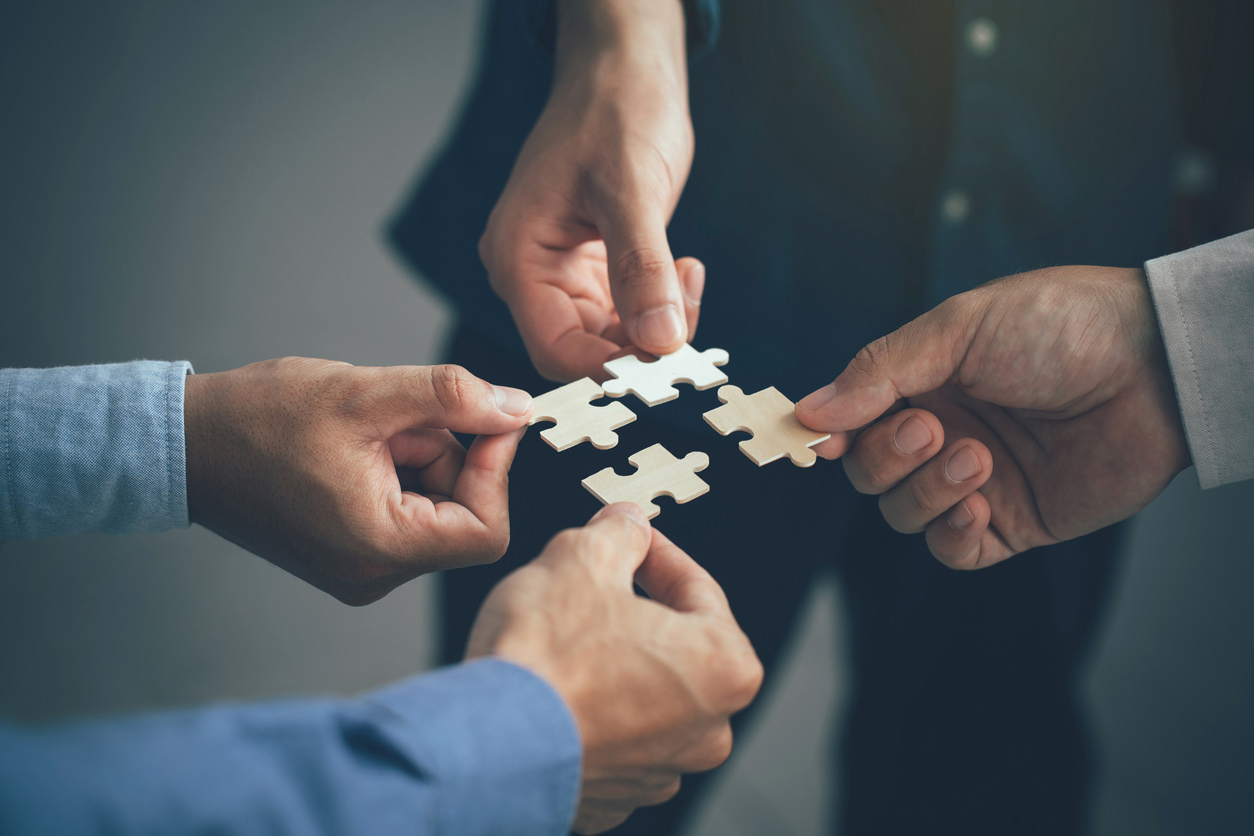 Concept of teamwork and partnership. Hands join puzzle pieces in the office. business people putting the jigsaws team together.Charity, volunteer. Unity, team business.